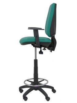 Modelo taburete Elche S - Taburete ergonómico con mecanismo asincro y regulable en altura - Asiento y respaldo tapizados en tejido BALI color verde esmeralda. Brazos regulables incluidos de serie. Aro reposapiés cromado.