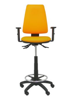Modelo taburete Elche S - Taburete ergonómico con mecanismo asincro y regulable en altura - Asiento y respaldo tapizados en tejido SIMILPIEL color naranja. Brazos regulables incluidos de serie. Aro reposapiés cromado.