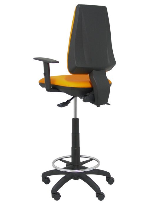 Modelo taburete Elche S - Taburete ergonómico con mecanismo asincro y regulable en altura - Asiento y respaldo tapizados en tejido SIMILPIEL color naranja. Brazos regulables incluidos de serie. Aro reposapiés cromado.