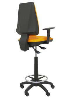 Modelo taburete Elche S - Taburete ergonómico con mecanismo asincro y regulable en altura - Asiento y respaldo tapizados en tejido SIMILPIEL color naranja. Brazos regulables incluidos de serie. Aro reposapiés cromado.